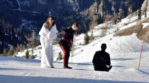 Couple in the snow with the Dolomites and a photographer