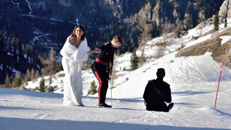 Couple in the snow with the Dolomites and a photographer