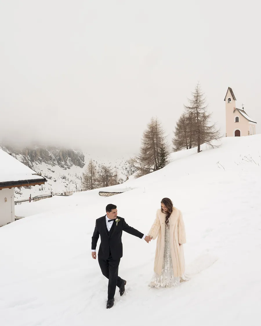 Couple walking in the snow during an elopement in Cortina
