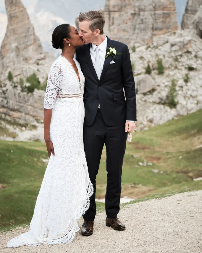 Bride and groom kissing beneath the Dolomites