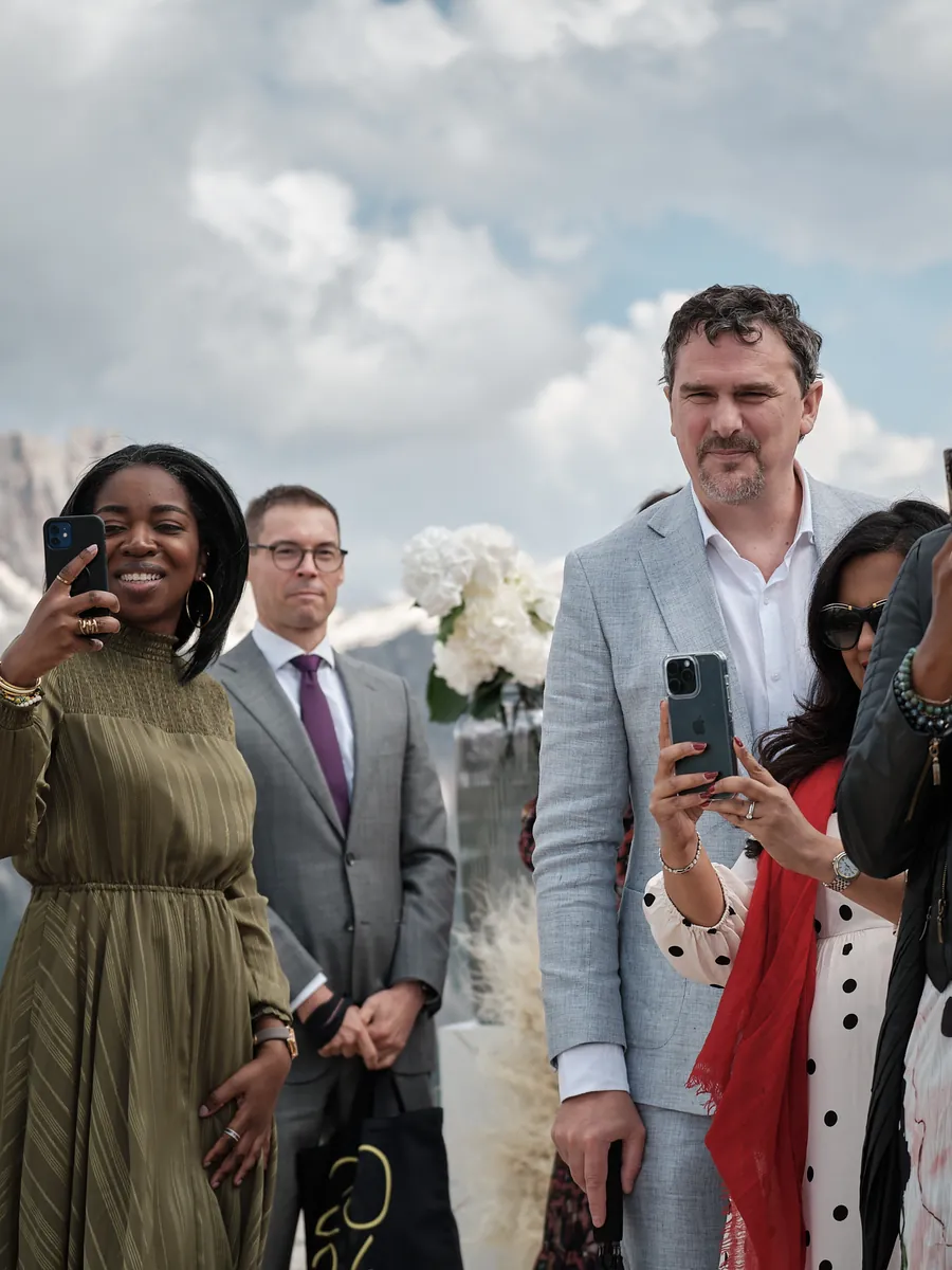 Wedding guests photographing the ceremony in the Dolomites