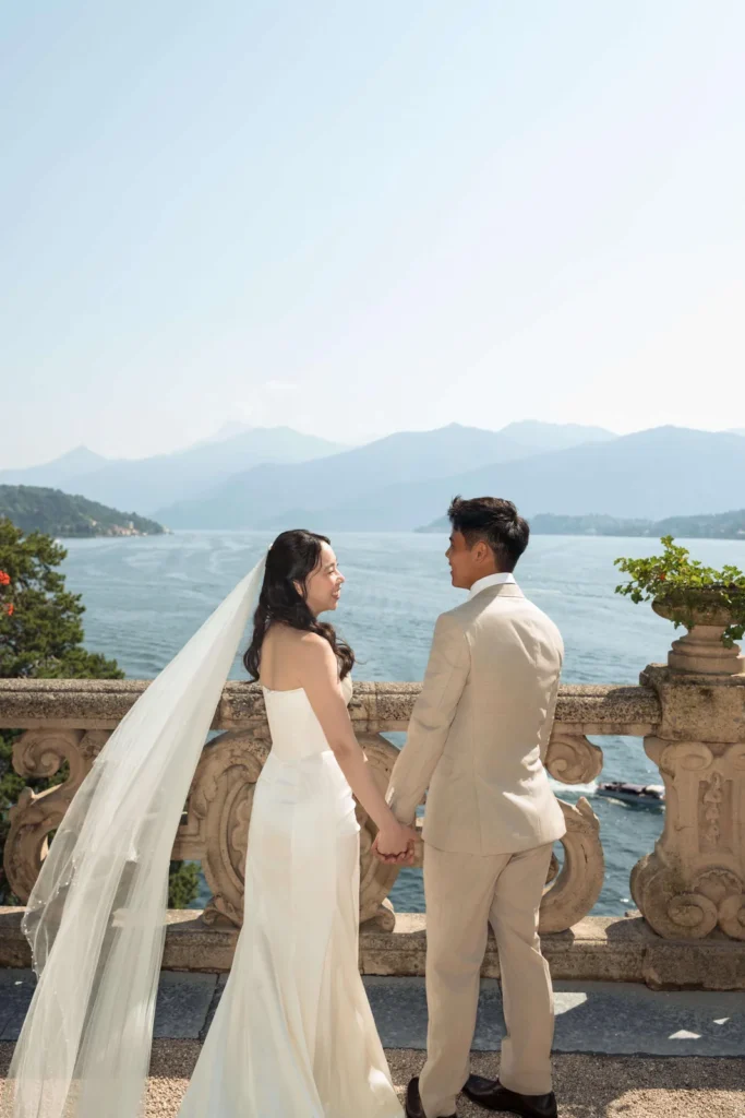 Bride and groom looking out over Lake Como from the villa terrace