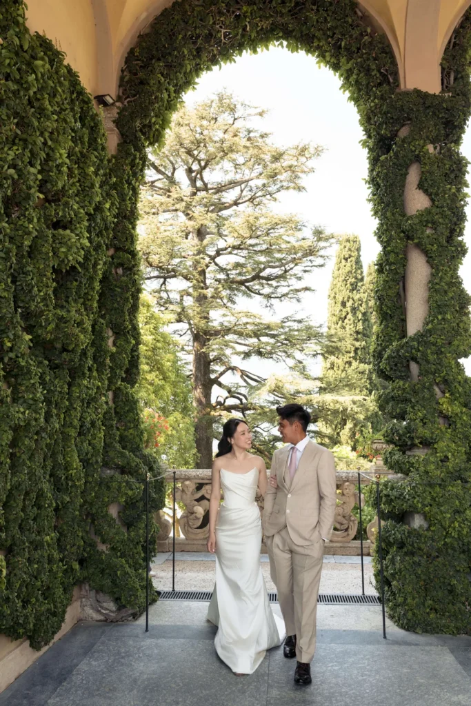 Couple walking through an ivy arch at Villa del Balbianello
