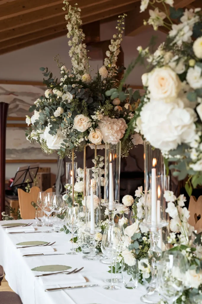 Wedding table with tall white floral centrepieces and candles