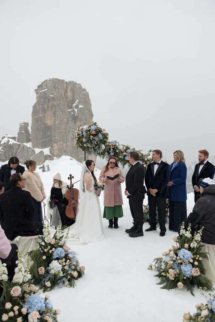 Winter wedding ceremony at the Cinque Torri with guests in the snow
