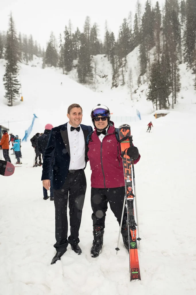 Bride and groom in wedding attire with skis on the slopes