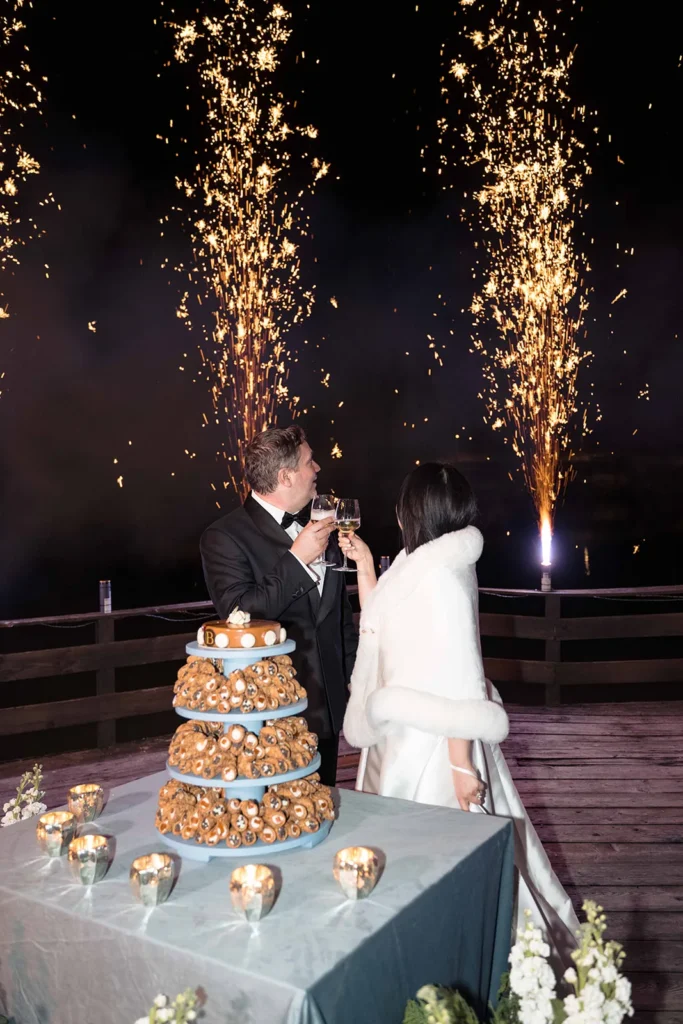 Bride and groom cutting the cake under fireworks