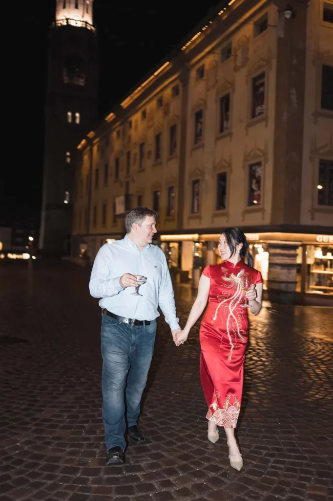Bride in a red dress and groom walking through Cortina at night