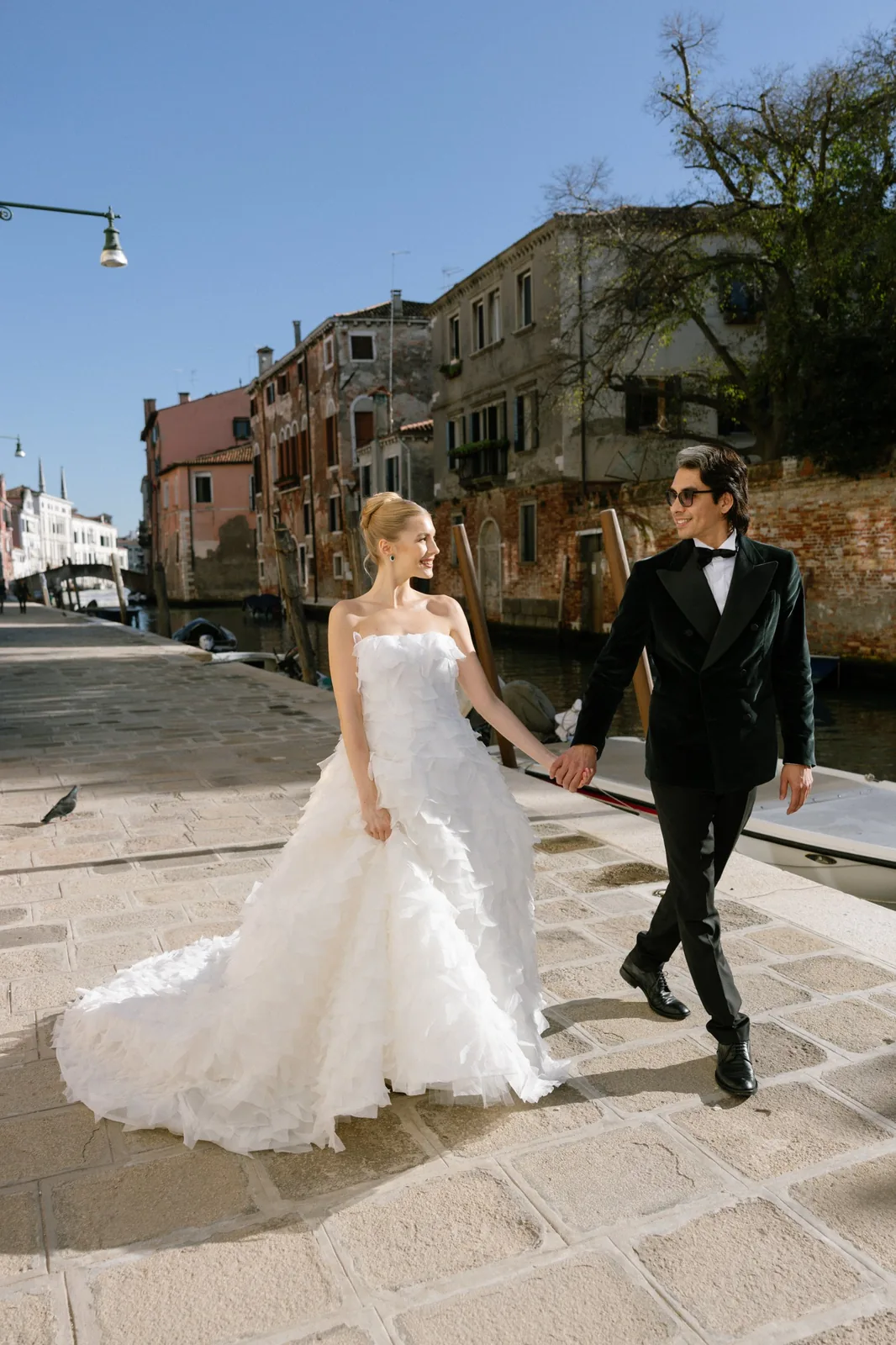 Newlyweds walking along a Venice canal